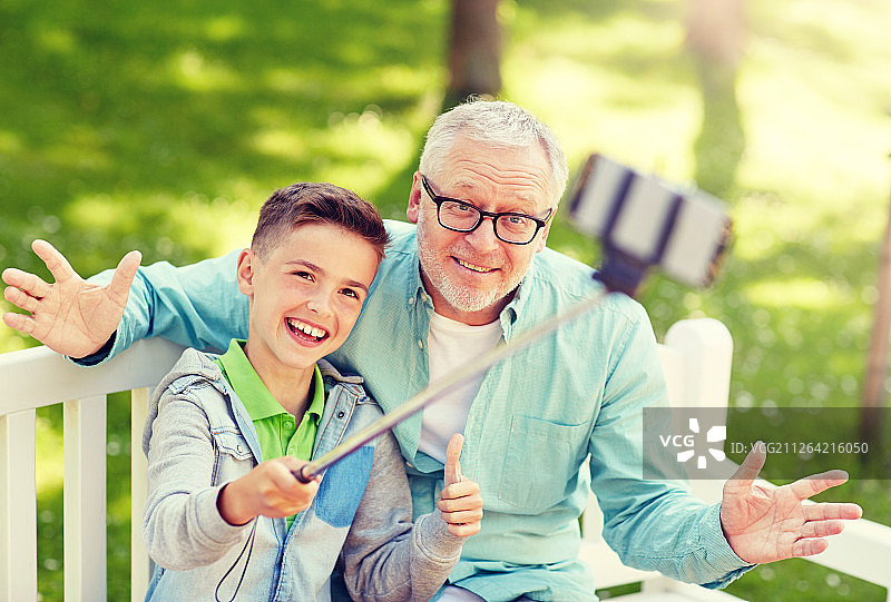 祖孙在夏日公园用自拍杆自拍图片素材