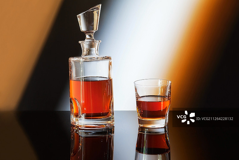 渐变背景上的威士忌酒瓶和酒杯图片素材