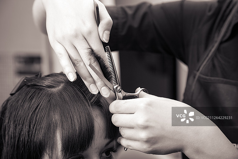 在沙龙中设计发型的美发师室内拍摄图片素材