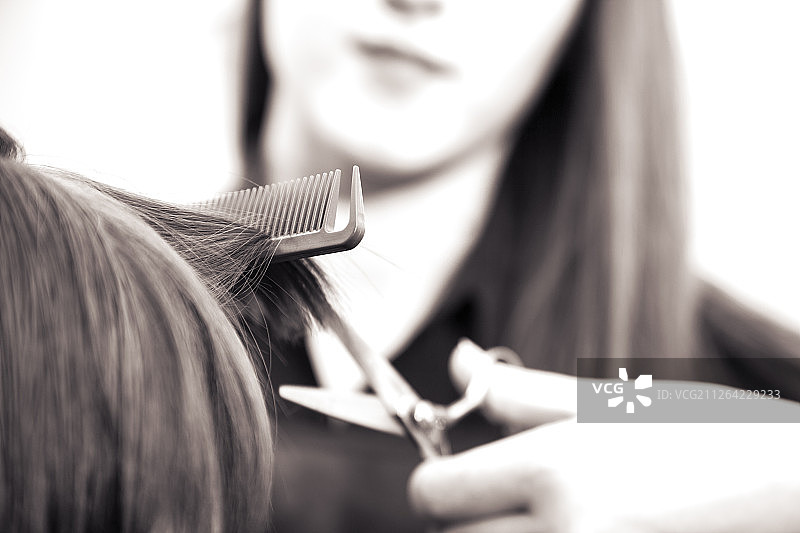 在沙龙中设计发型的美发师室内拍摄图片素材