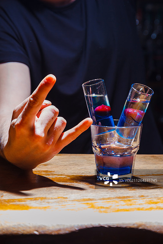 红色和蓝色分层及樱桃装饰的异国情调鸡尾酒特写图片素材