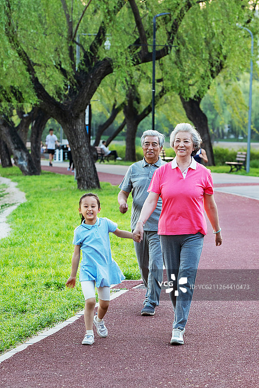 老年夫妇带着孙女在户外散步图片素材