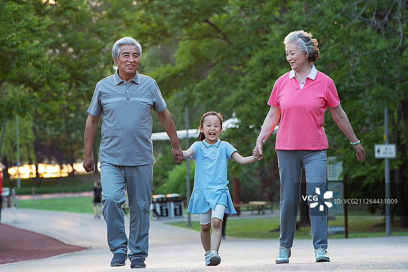 老年夫妇带着孙女在户外散步图片素材