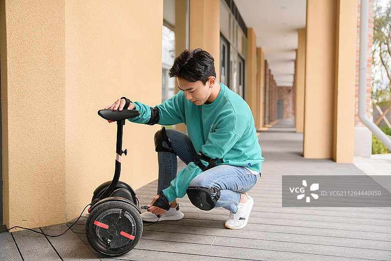 智能出行生活概念：使用电动汽车的年轻人图片素材