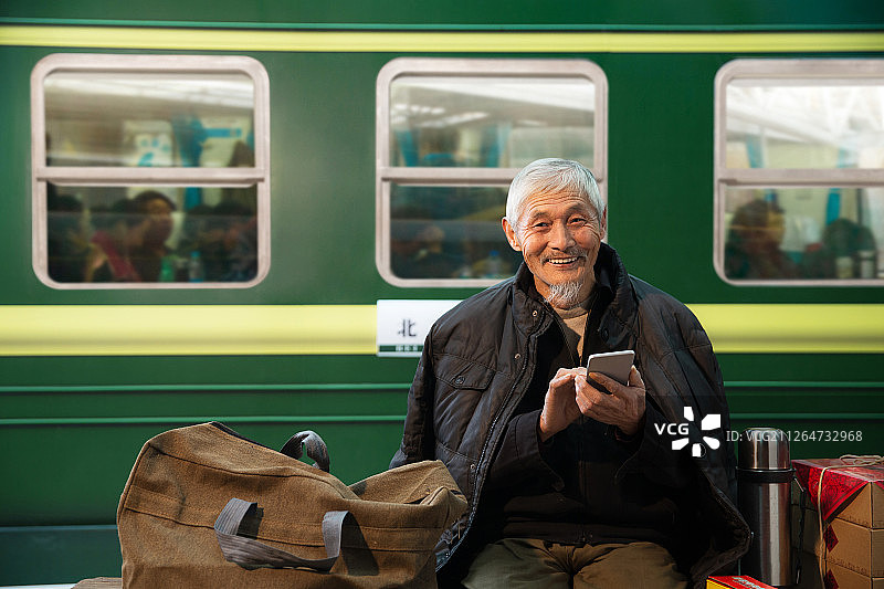 在火车站台上用手机的老人图片素材