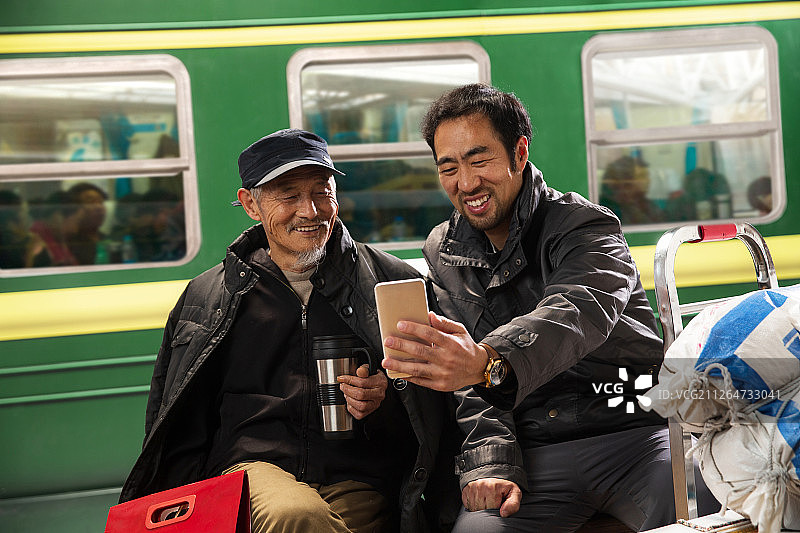 在火车站台上看手机的旅客图片素材