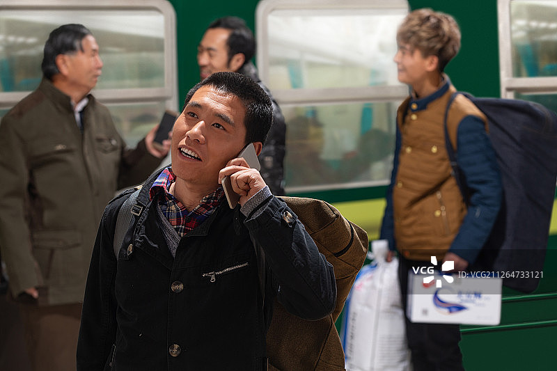 站在火车月台上打电话的旅客图片素材