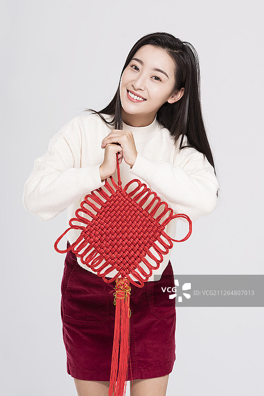 年轻女子手拿中国结庆贺新年图片素材