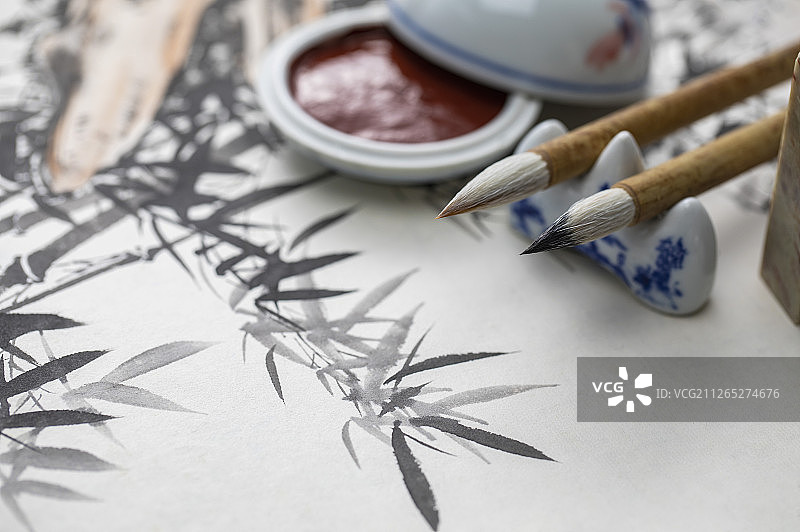 毛笔和印泥搁在画作上图片素材
