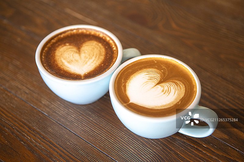 二杯含有爱心图案拉花的拿铁咖啡图片素材