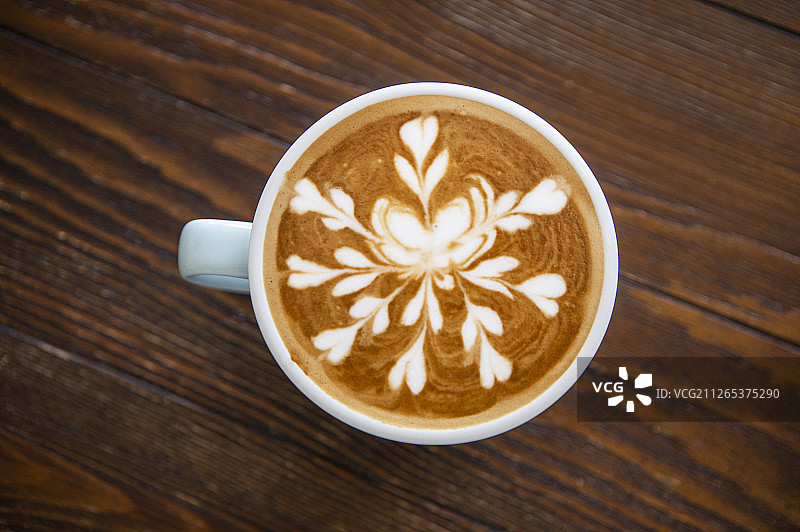 一杯含有漂亮图案拉花的拿铁咖啡图片素材