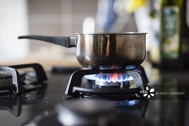 燃气灶火焰下的金属锅图片素材