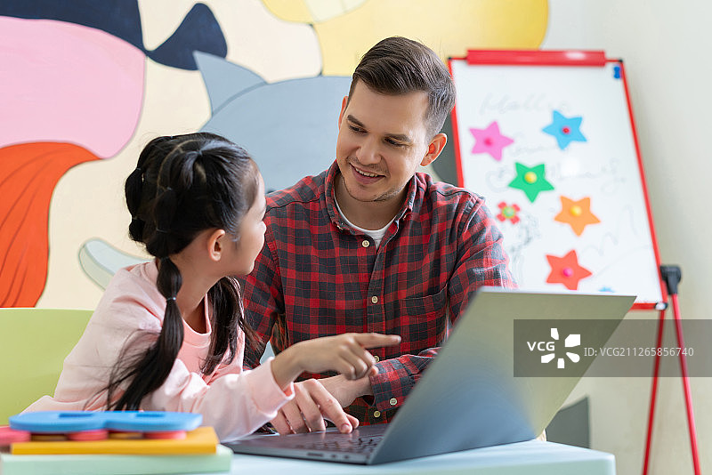 老师在课堂上辅导小学生用电脑图片素材
