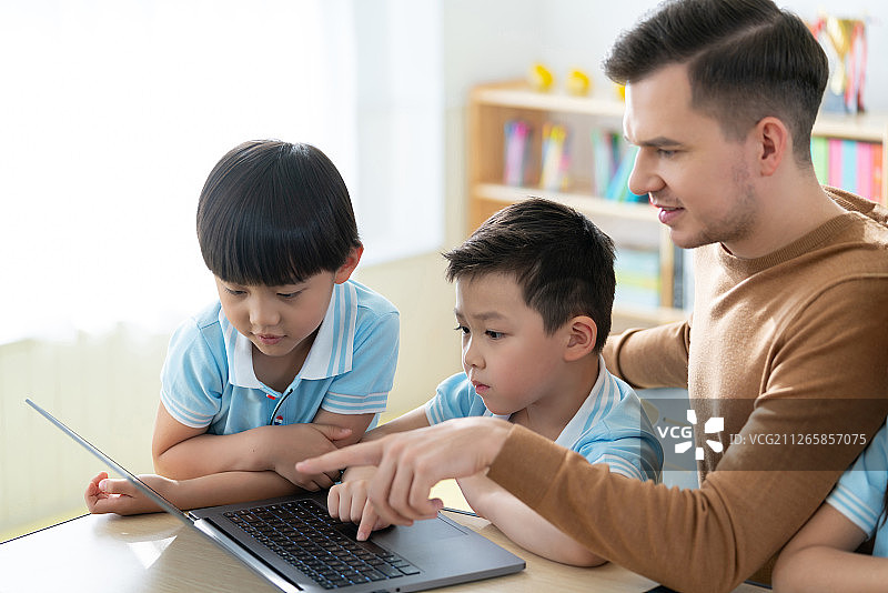 老师在课堂上辅导小学生用电脑图片素材