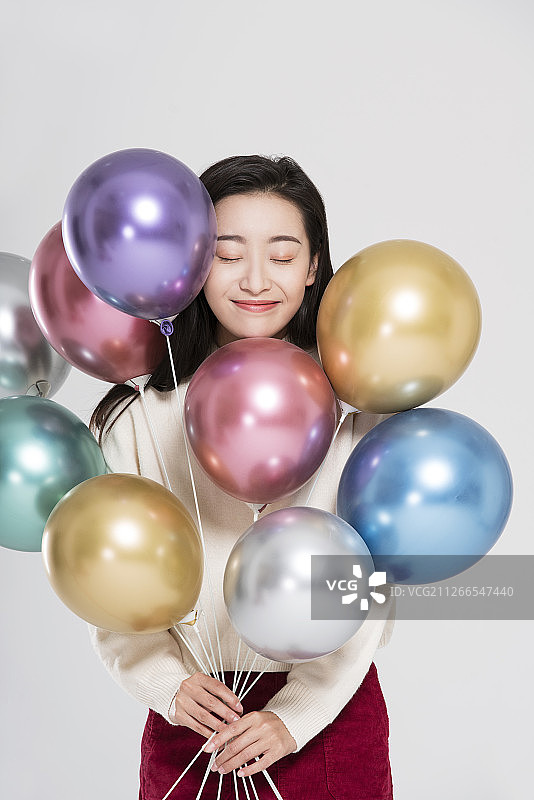美丽的年轻女子拿着气球图片素材
