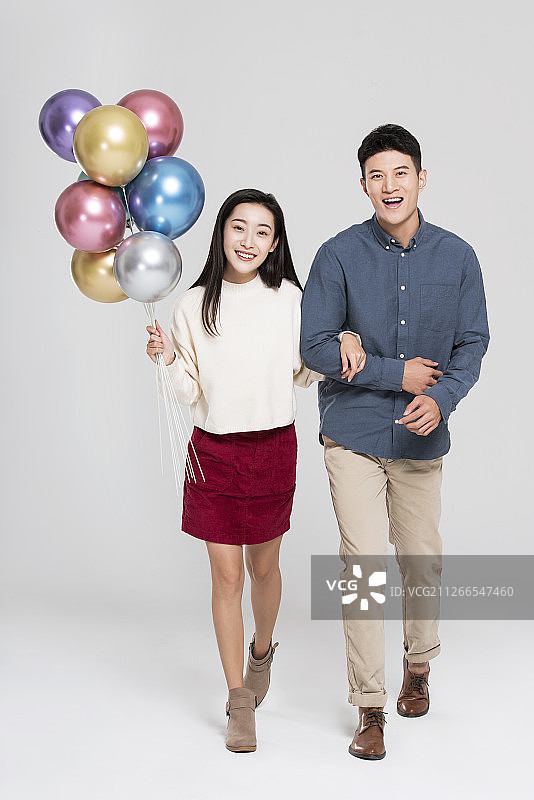 快乐的年轻情侣拿着气球图片素材