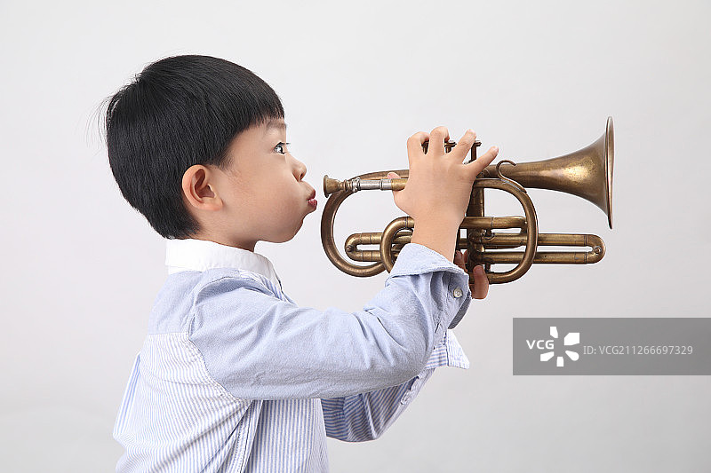 一个吹小号的亚洲男孩图片素材