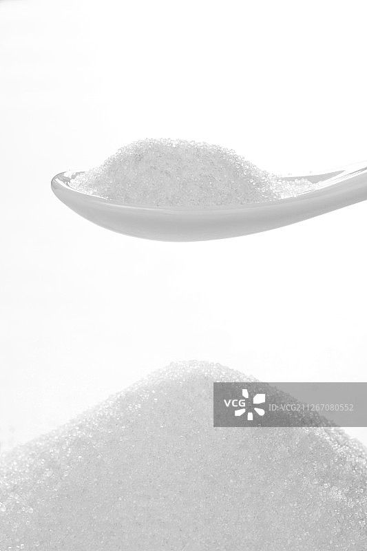 在白色背景前的食盐，盐粒。图片素材