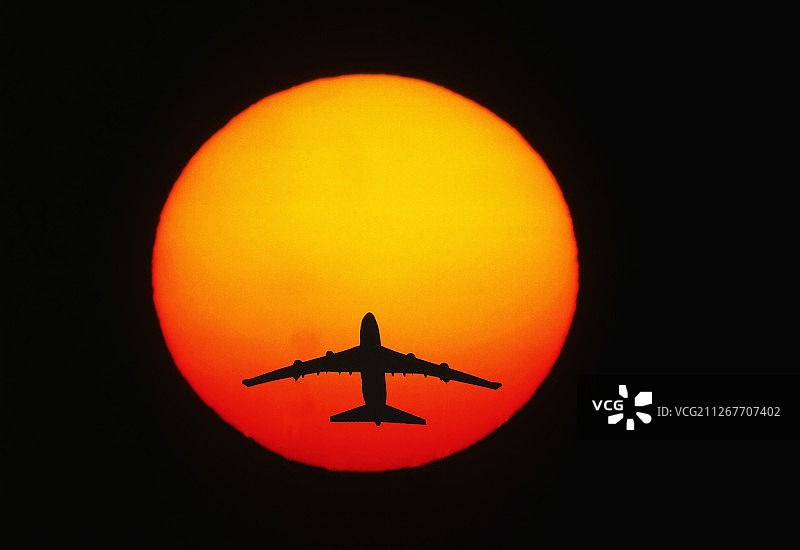 波音747-400飞机在阳光下起飞的轮廓图片素材