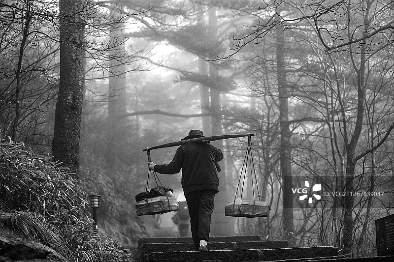 雨雾中的挑夫图片素材