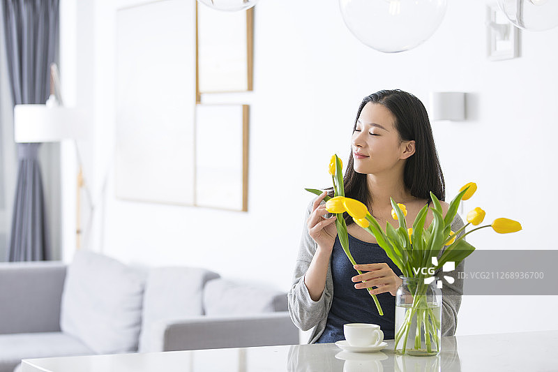 青年女子拿着郁金香在客厅图片素材