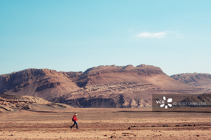 行走在荒芜的新疆火焰山下图片素材
