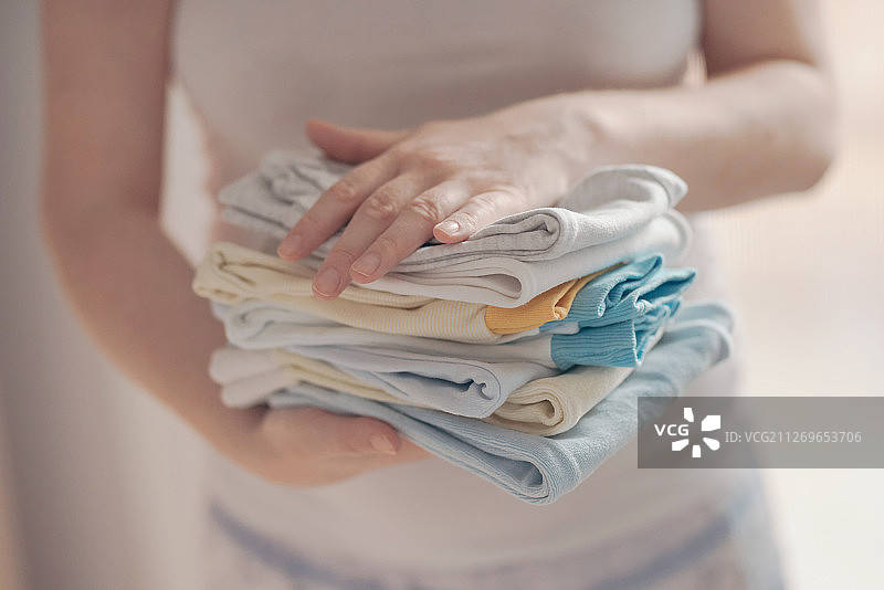 母亲拿着婴儿服装的截面图图片素材