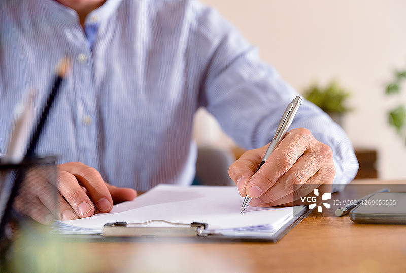 在办公室的记事本上写作的男人图片素材