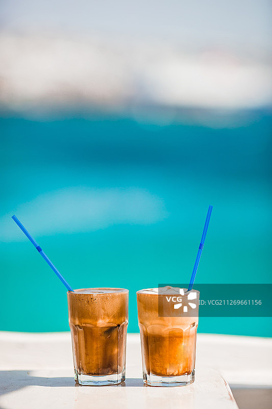 木桌上的拿铁咖啡，背景为海景图片素材