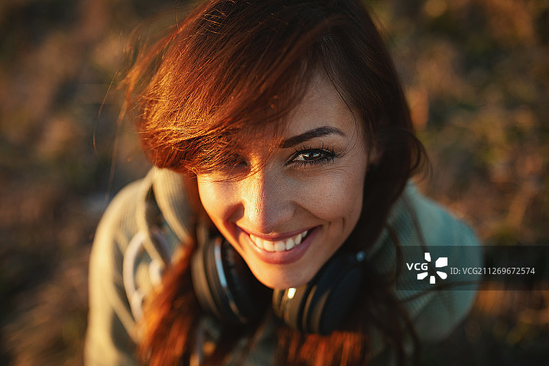 戴着耳机看向镜头的年轻女人图片素材