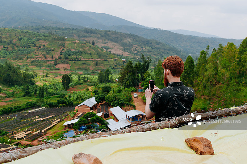 男游客在卢旺达吉他拉马拍摄乡村风景图片素材