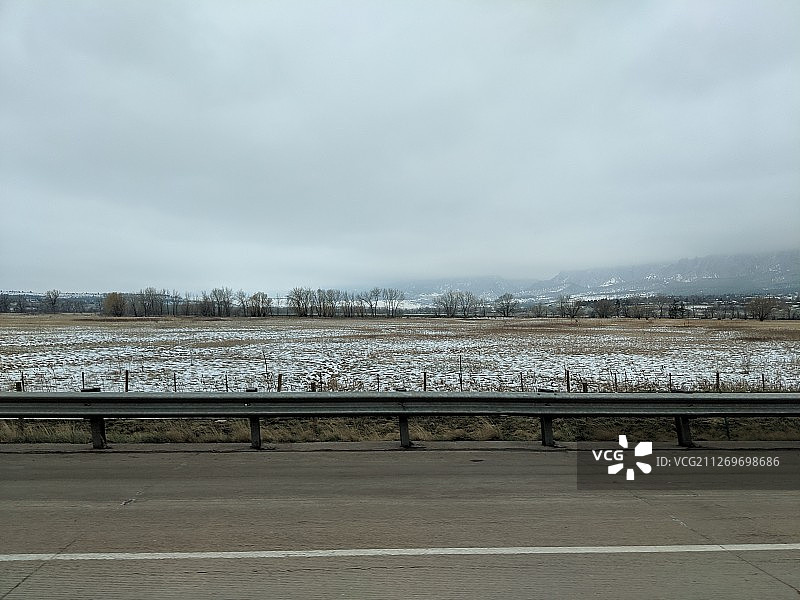 美国博尔德：雪树覆盖的田野和公路护栏图片素材