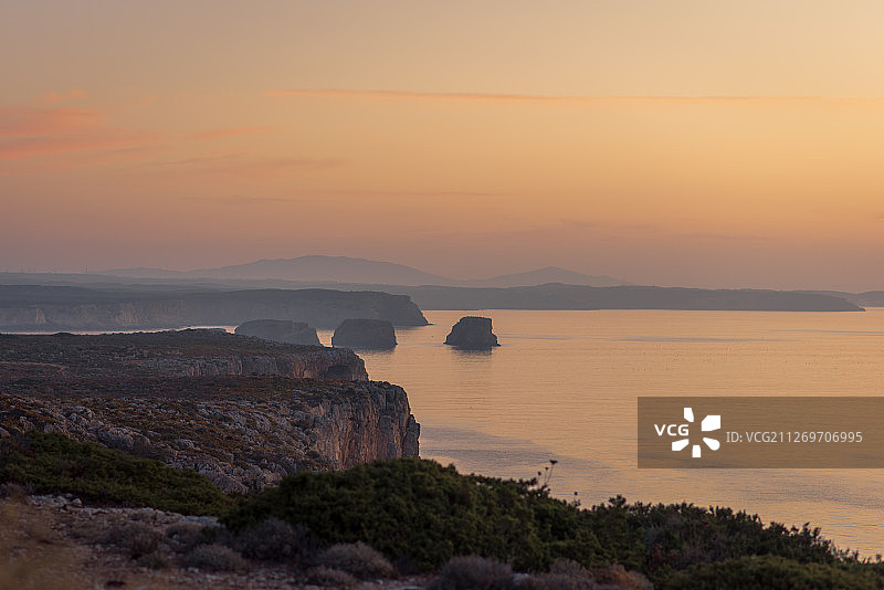 葡萄牙阿尔加维萨格里什日出前的橙色天空和岩石海岸线图片素材