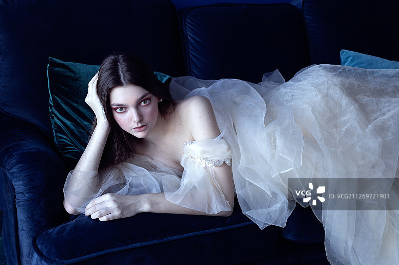 躺在床上，身穿白色连衣裙的女人图片素材
