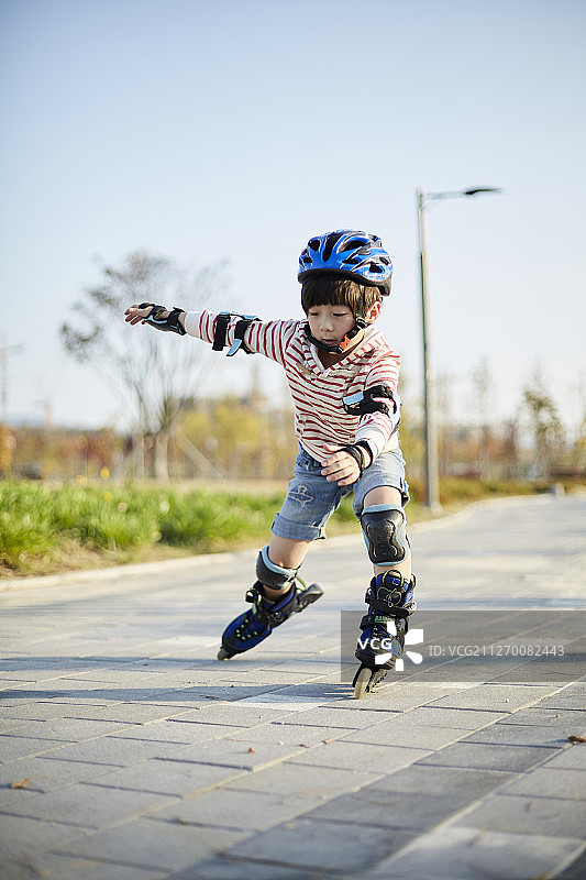 在公园里玩轮滑摔倒的小男孩照片图片素材