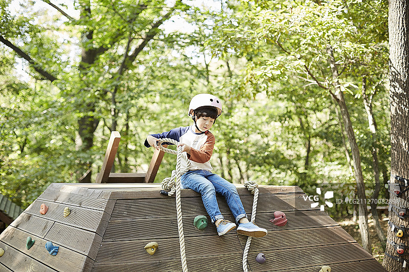 戴头盔的小男孩在公园游乐场玩耍的摄影图片素材