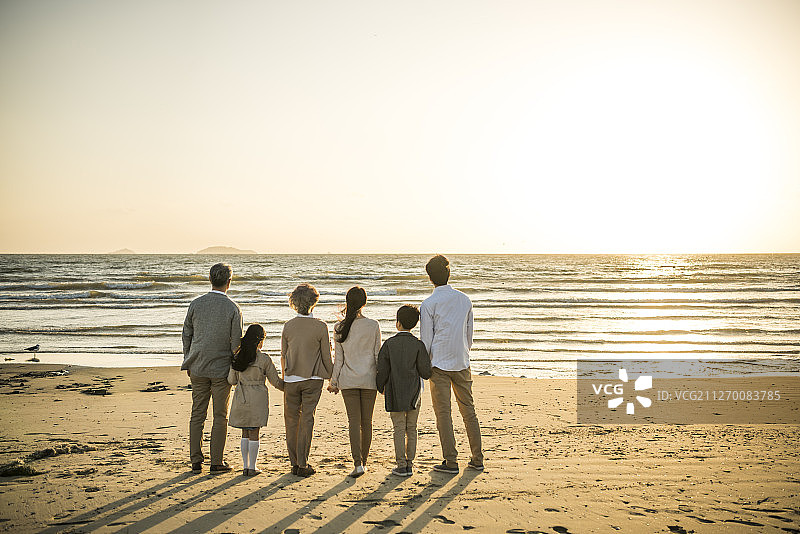 在海滩观看日落的一家人的摄影作品图片素材