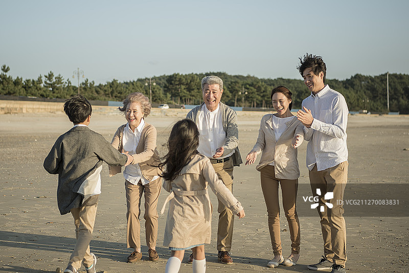 大家庭在海滩上迎接孩子图片素材
