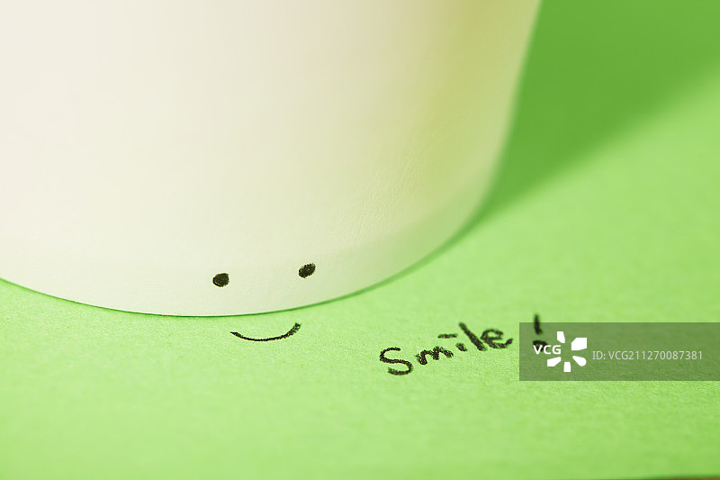 带有微笑信息和面部表情的纸杯和纸张的影棚照片图片素材