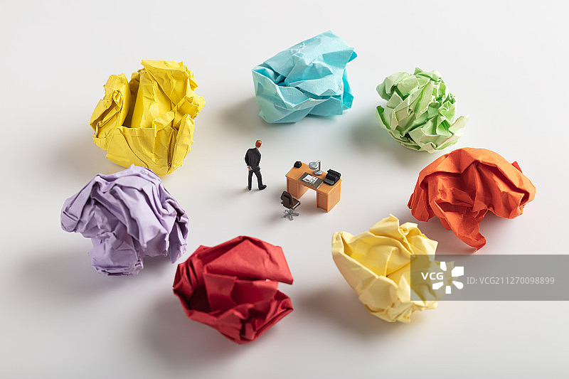 彩色纸团内的办公桌思考商务男性图片素材