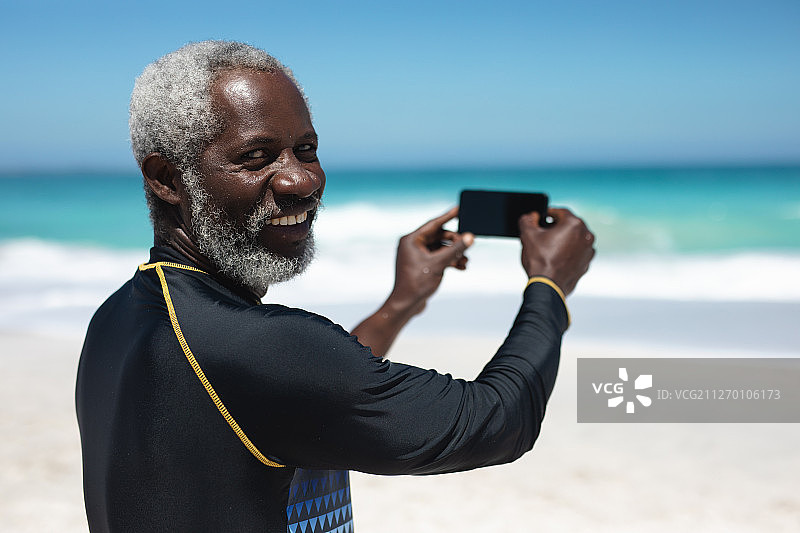 在海滩上拍照的老人图片素材