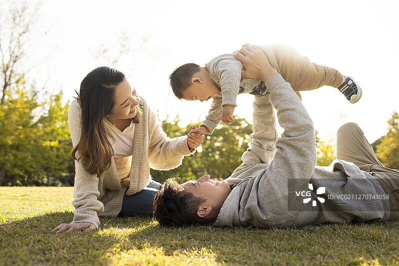 幸福的一家三口在草地上玩耍图片素材