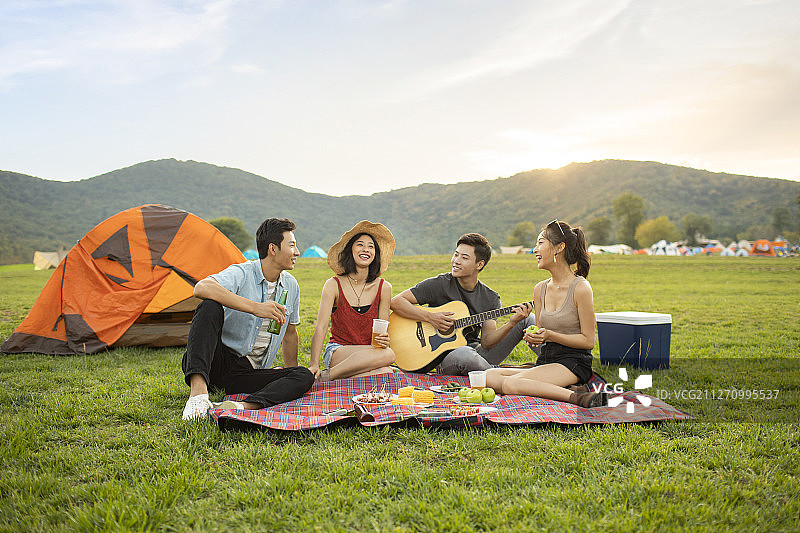 快乐的年轻朋友在户外野餐图片素材