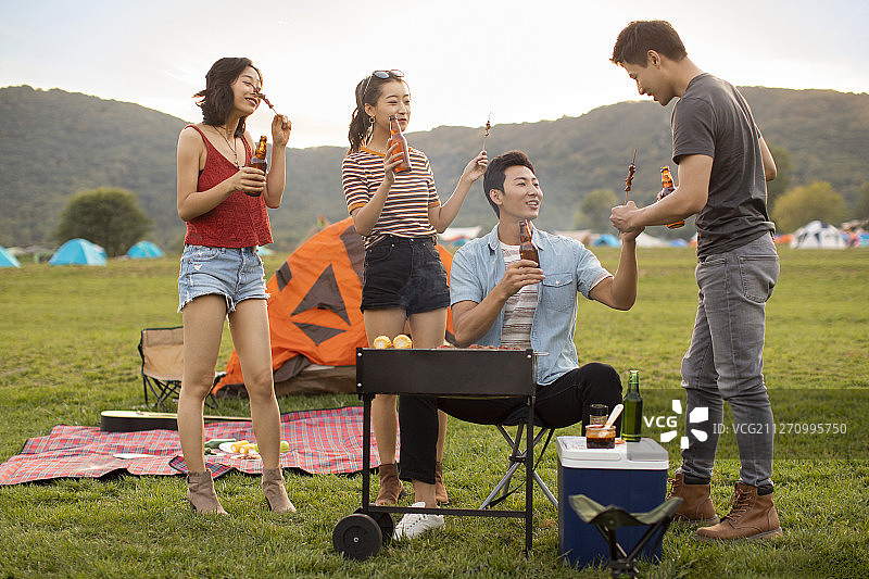 快乐的年轻朋友在户外烧烤图片素材