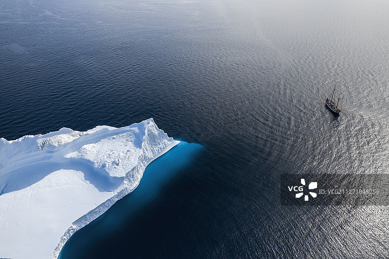 格陵兰岛阳光明媚的北大西洋上驶过北极冰山的船舶图片素材