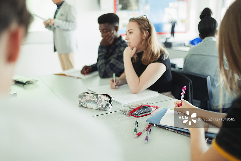 高中生在教室的桌子旁学习图片素材