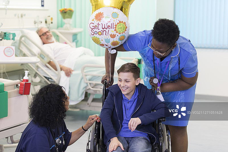 医生和护士与坐轮椅的男童患者在病房交谈图片素材