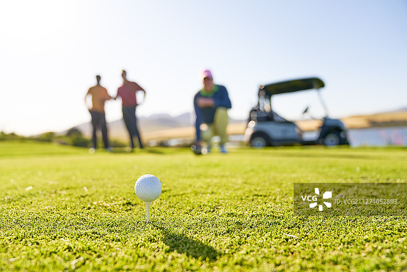 阳光明媚的球座上摆放着高尔夫球图片素材