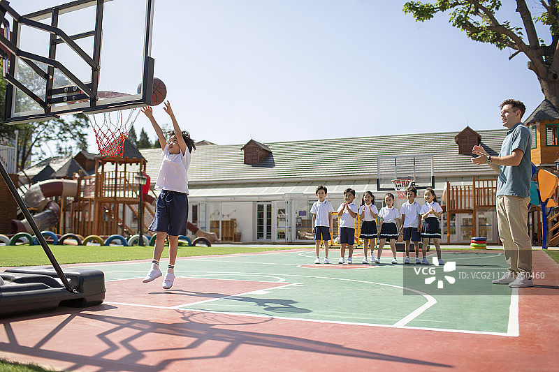 外教和孩子在操场打篮球图片素材