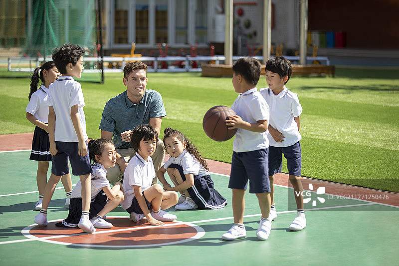 外教和孩子在操场打篮球图片素材